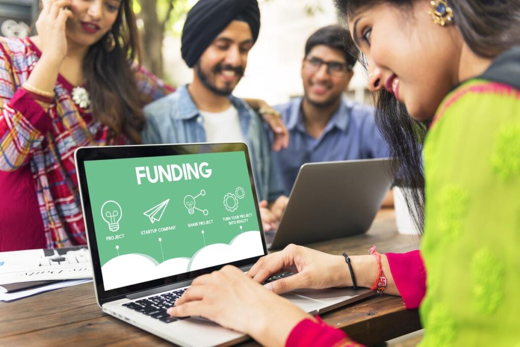 Grupo de pessoas acompanhando os resultados do crowdfunding pelo notebook.