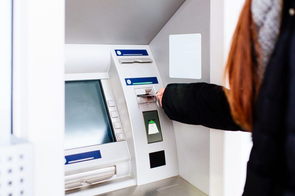 Mulher usando o caixa eletrônico para sacar dinheiro da sua conta do Cash App.