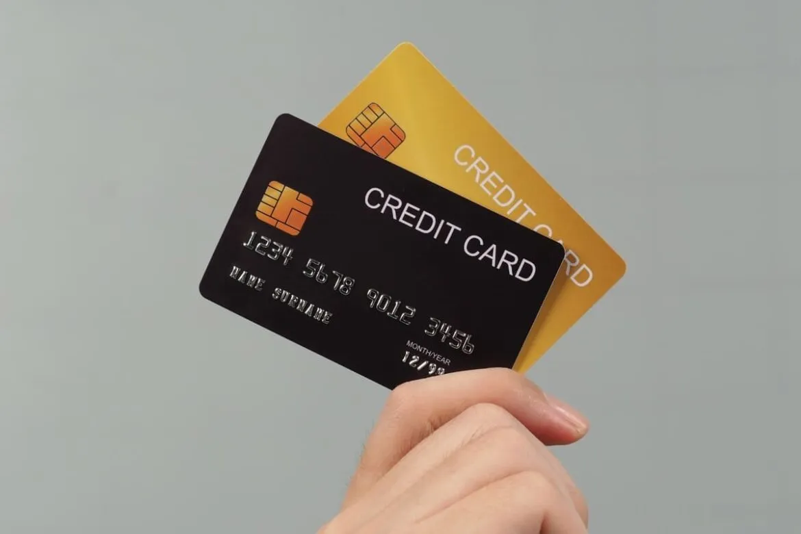 Pessoa segurando cartão de crédito sem anuidade.