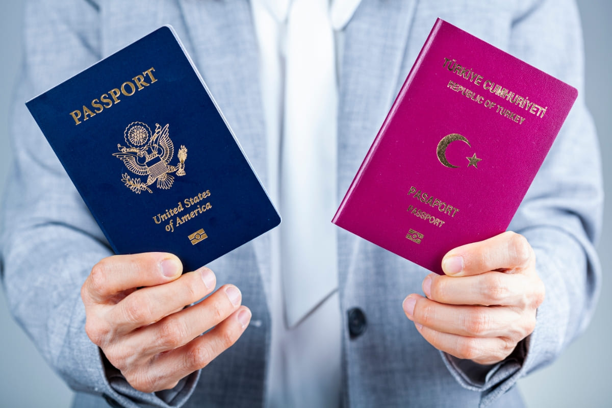 Pessoa com dupla cidadania segurando dois passaportes.
