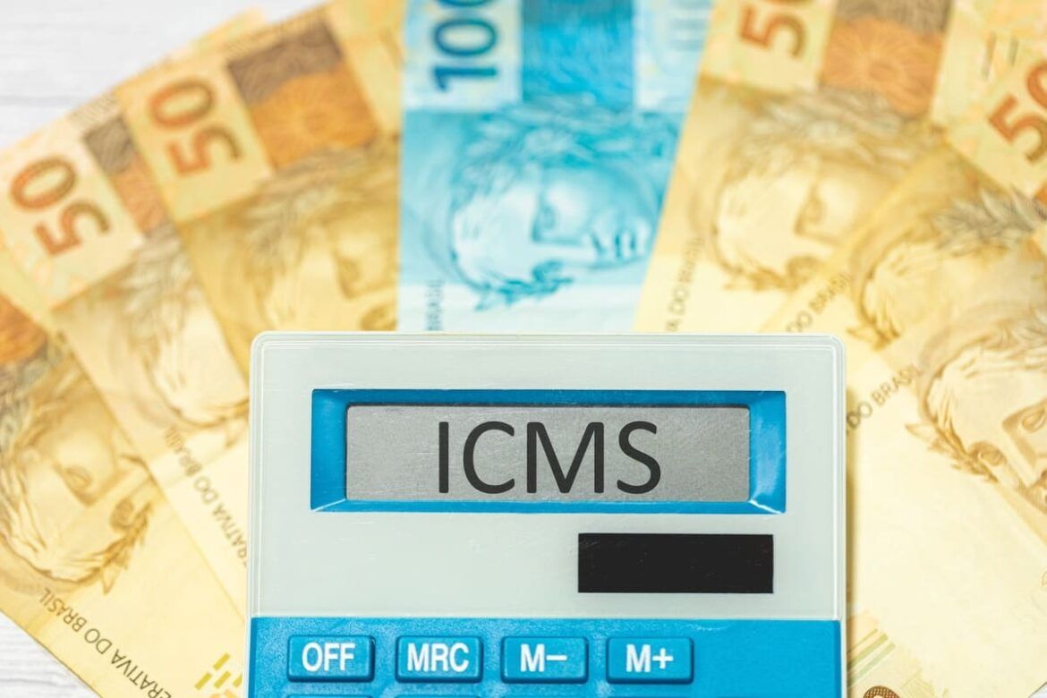 A sigla ICMS referente ao Imposto sobre Circulação de Mercadorias e Serviços escrita na tela de uma calculadora com Real, para ilustrar um texto sobre Incentivos fiscais de ICMS