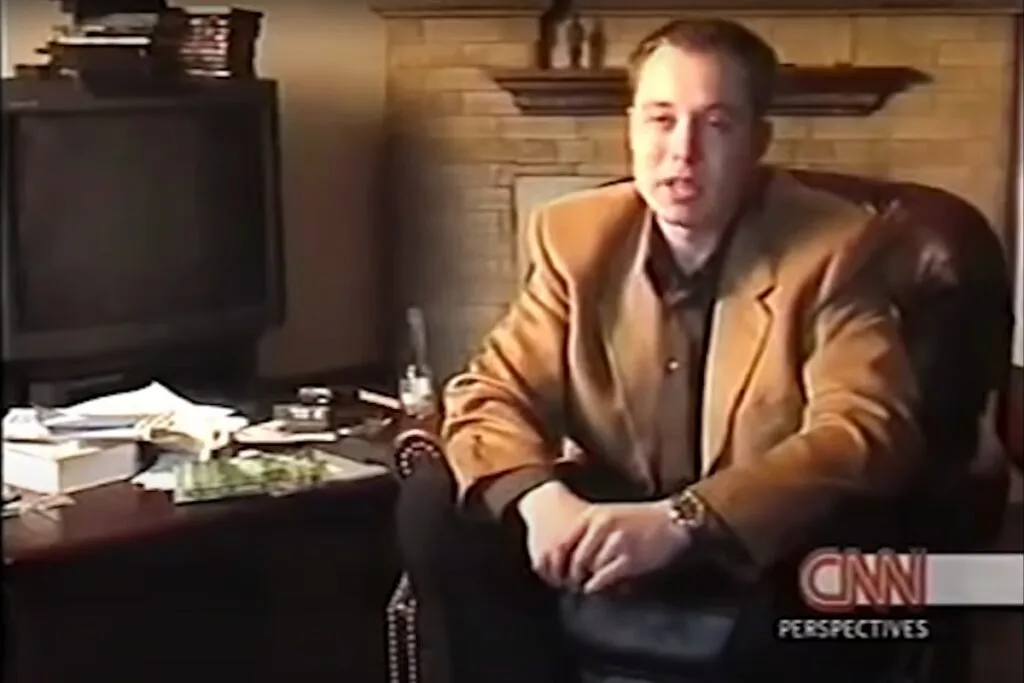 Foto de Elon Musk calvo quando era jovem durante entrevista.