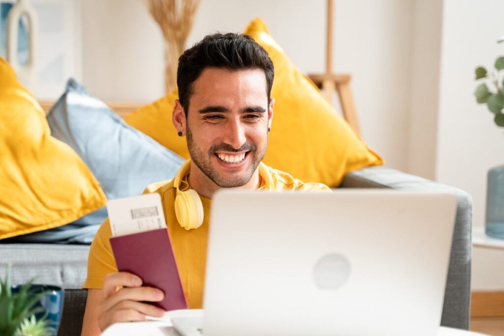 Homem usando o notebook para reservar passagens pela TAP Portugal.
