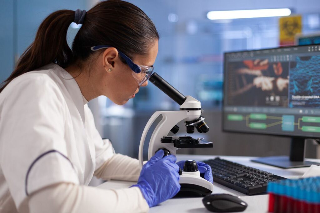 Biomédica analisando os resultados do teste de DNA de ancestralidade.