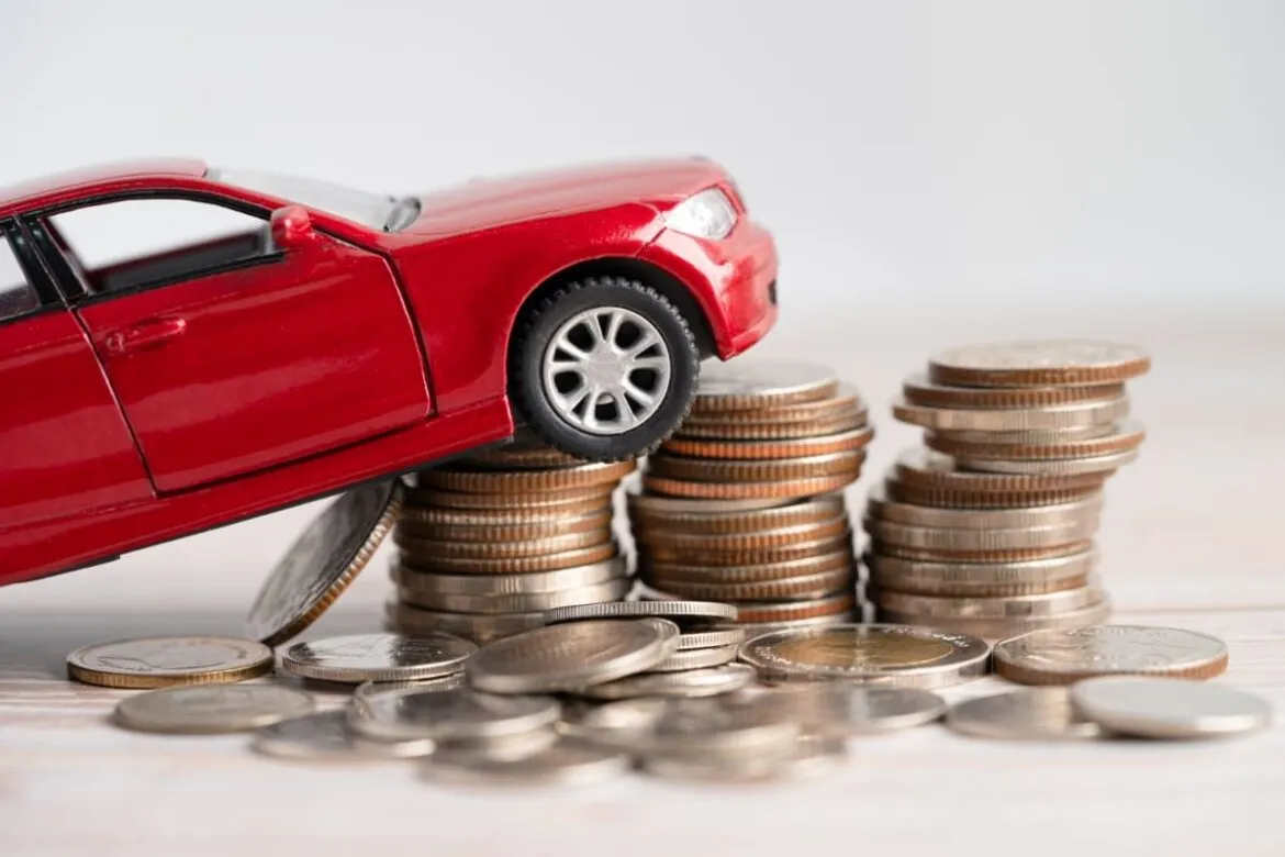 Foto de um carro sobre moedas de dinheiro para falar sobre como refinanciar veículo.