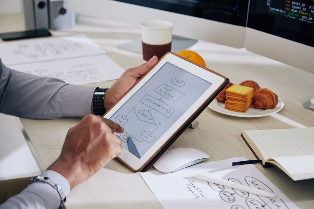 Profissional criando diagrama no Lucidchart pelo tablet.