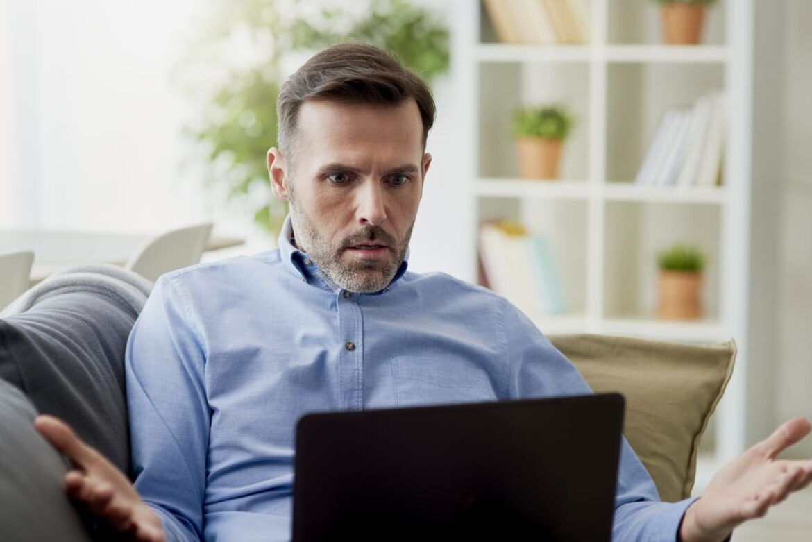Homem irritado em frente ao computador para ilustrar um texto sobre o ChatGPT não está funcionando.