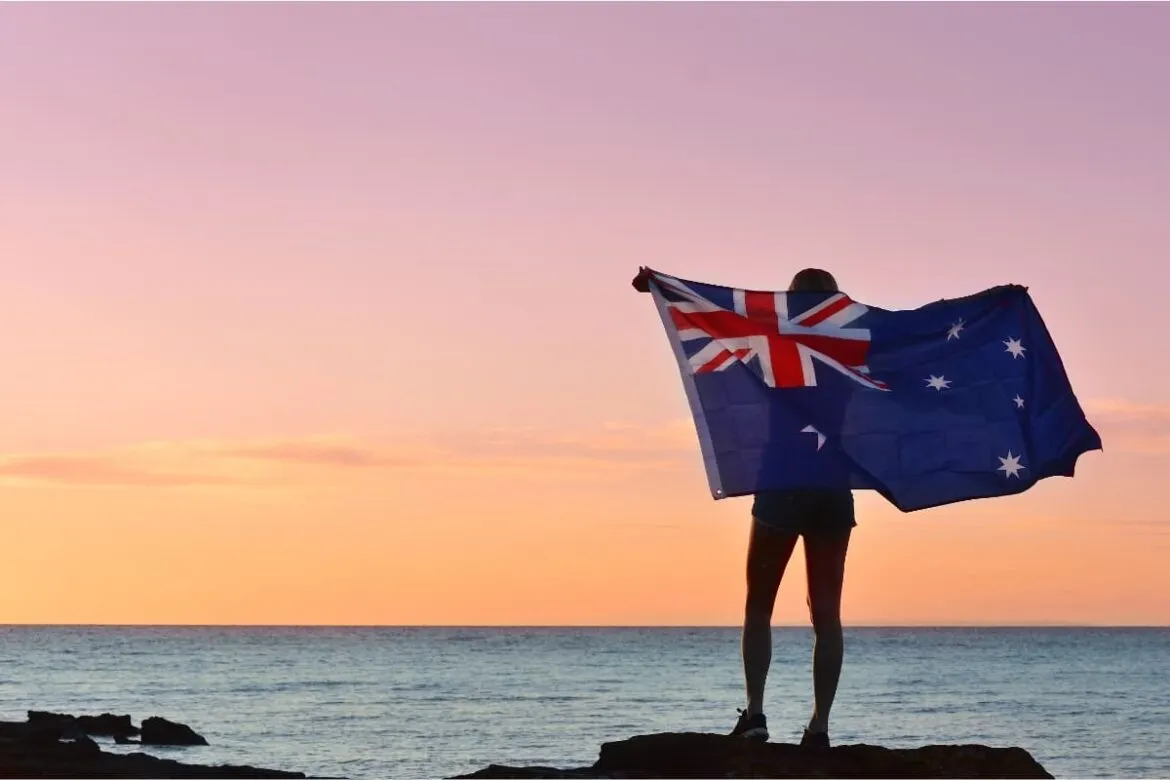 Pessoa segurando a bandeira da Austrália para falar sobre custo de vida na Austrália.