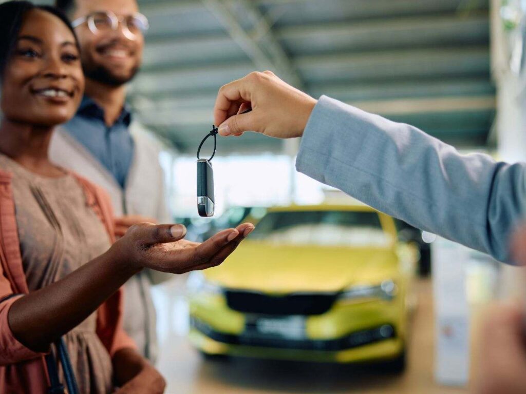Casal recebendo as chaves após comprar carro nos EUA.