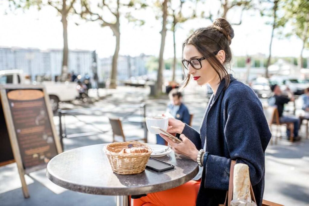 Mulher comendo croissant em um restaurante barato em Paris.