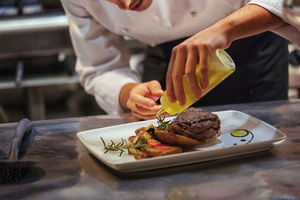Chef de restaurante em Paris finalizando o prato na cozinha.