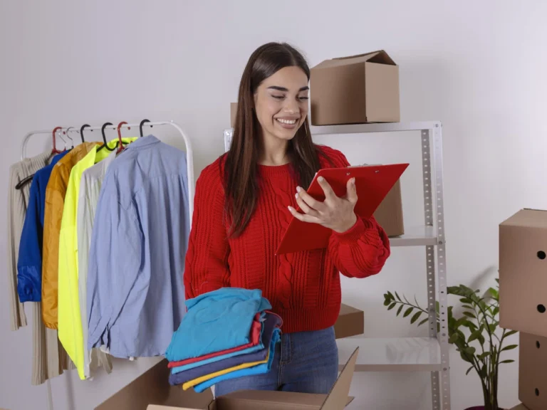 Mulher sorridente organizando roupas e verificando uma prancheta em seu estoque, ilustrando o guia de como vender na Shein sem estoque.