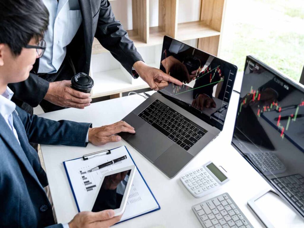 Consultor mostrando índices financeiros no computador