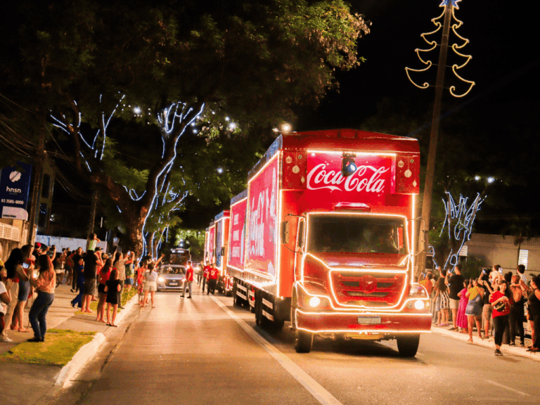 A caravana Coca-Cola 2025 percorre cidades brasileiras com caminhões iluminados e apresentações natalinas.