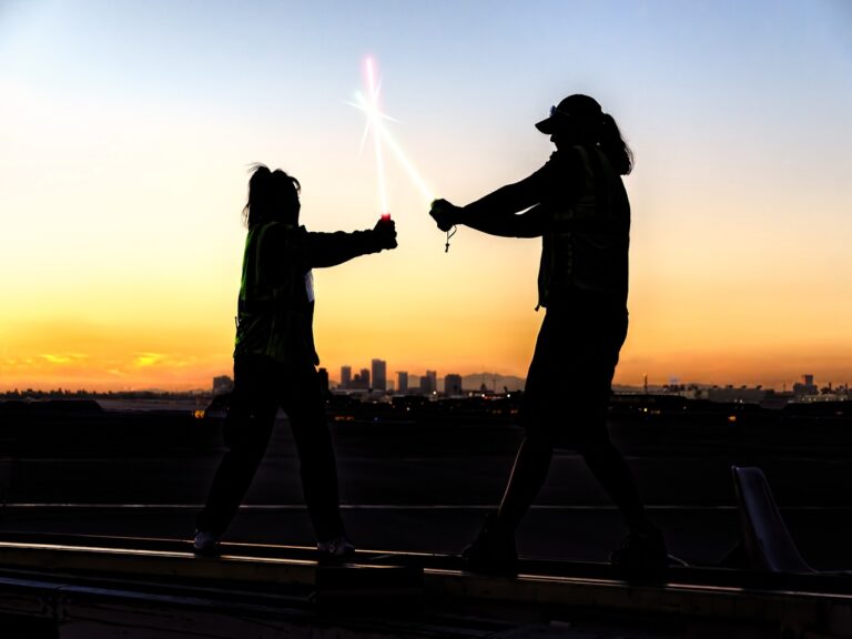 Duas pessoas com sabre de luz comemorando o Dia de Star Wars