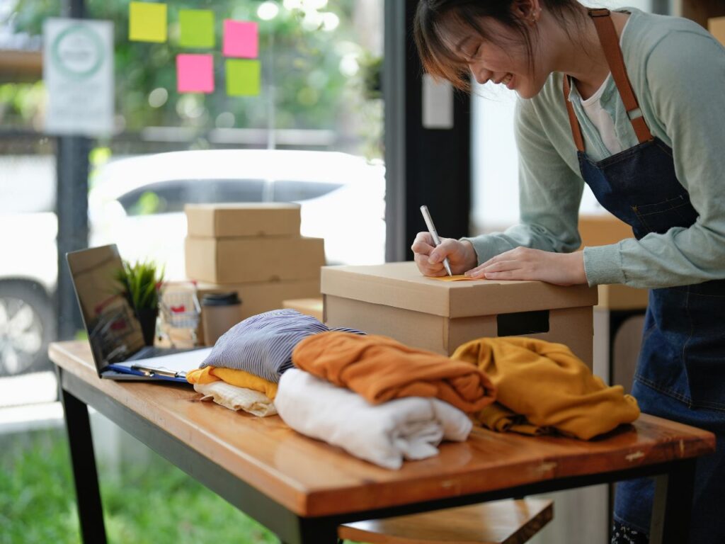 Mulher preparando roupas para importar da China com empresa Felipe Durante.