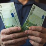 Homem contando seu salário mínimo em Portugal.