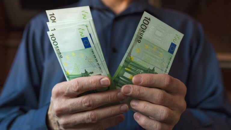 Homem contando seu salário mínimo em Portugal.