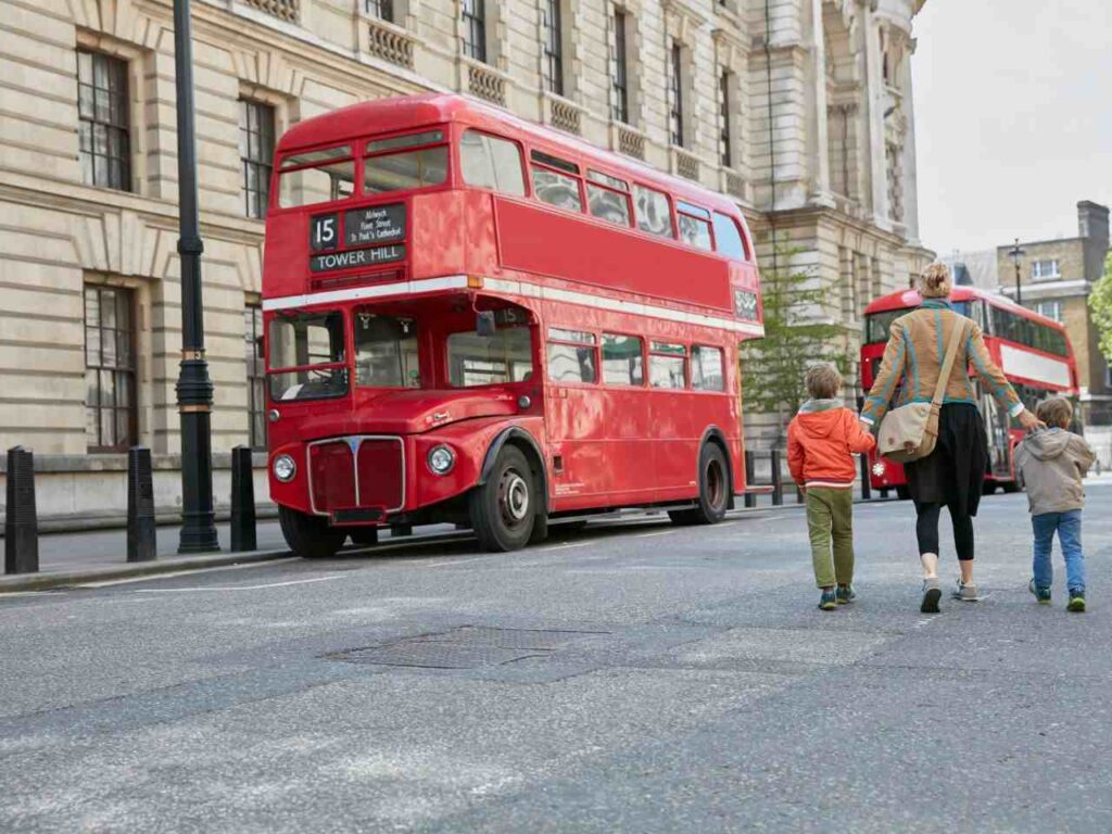 Mãe com filho perto do ônibus Hop-on Hop-off em Londres.