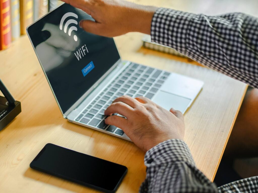 Homem com notebook com conexão Wi-Fi 7