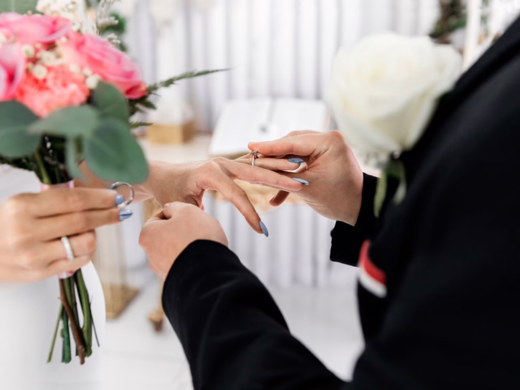 Homem colocando anel de casamento na esposa
