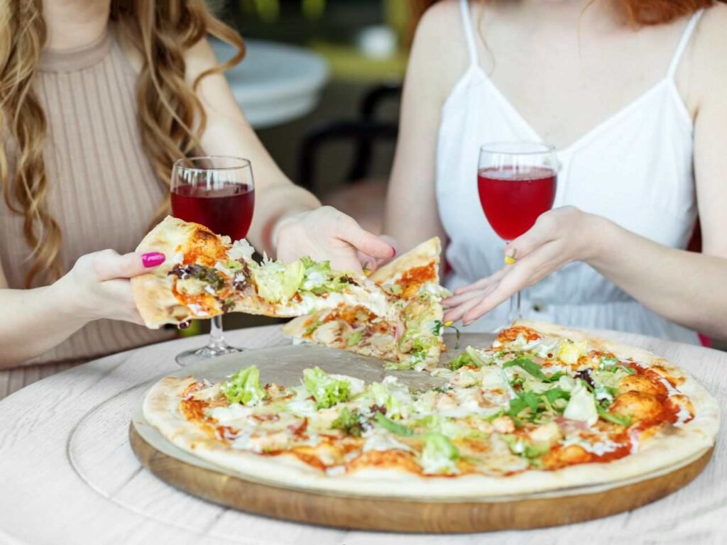 Duas turistas comendo pizza em Nápoles