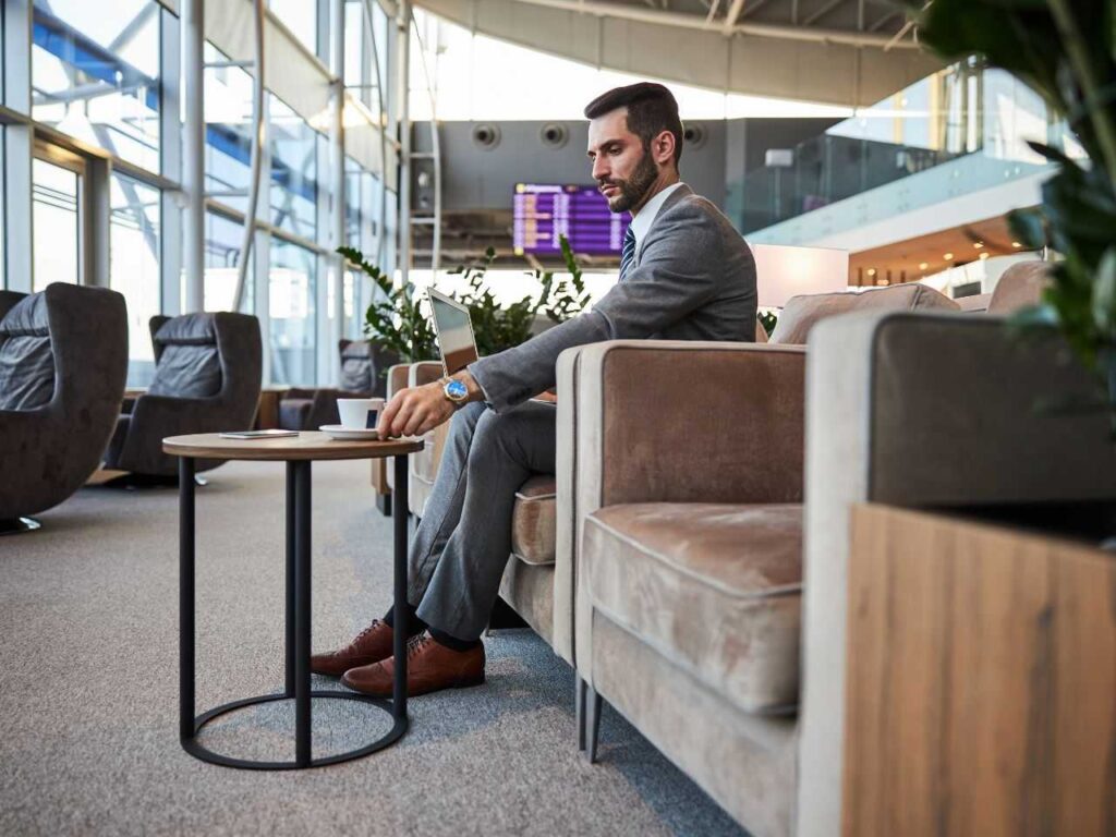 Homem trabalhando no notebook na sala VIP no Galeão