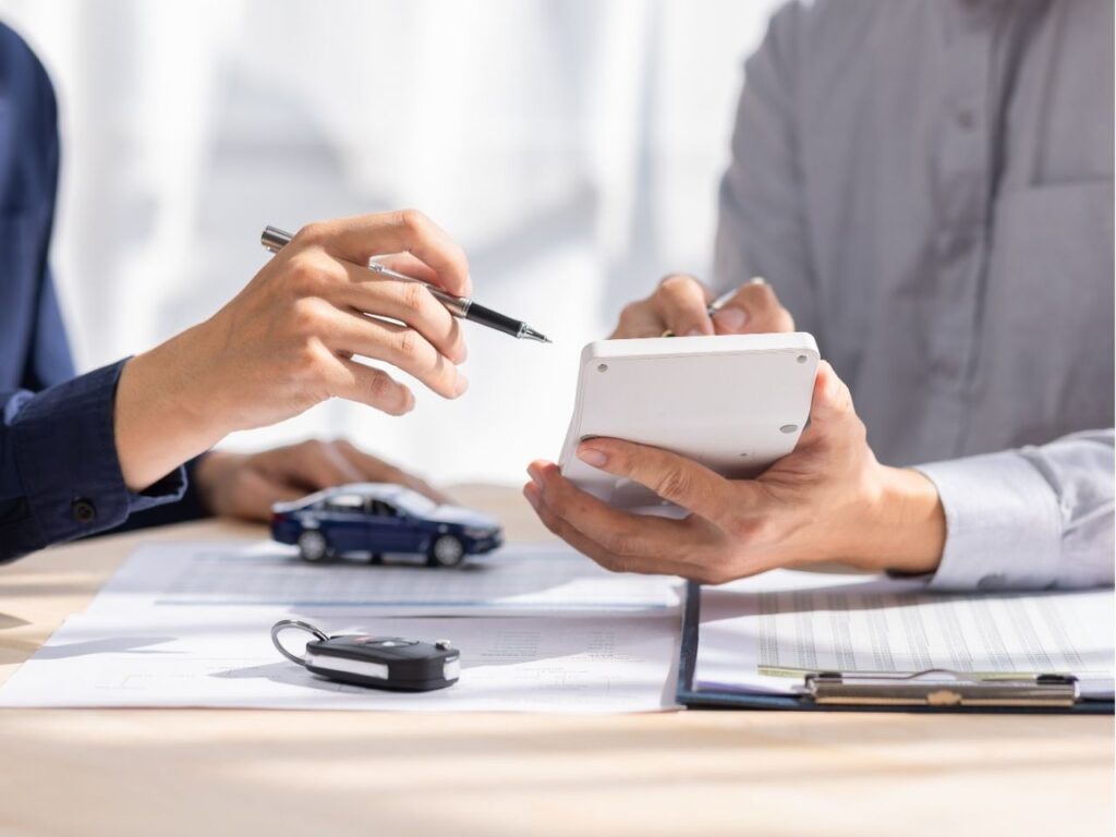 Homem calculando taxas de financiamento de carro