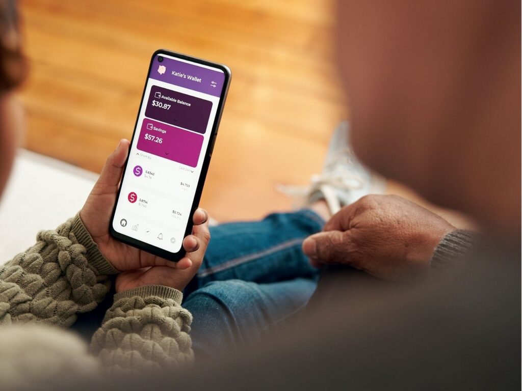 Homem e mulher lendo a tela do app de finanças pessoais