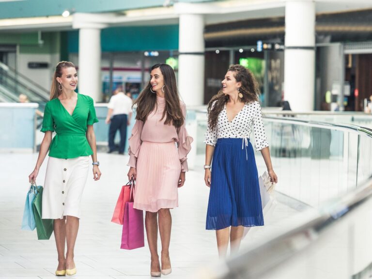 Três mulheres andando pelo shopping