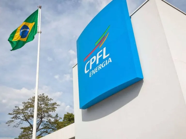 Fachada de um edifício com o logotipo azul da CPFL Energia em destaque e a bandeira do Brasil ao lado, facilitando a busca pelo CPFL telefone.