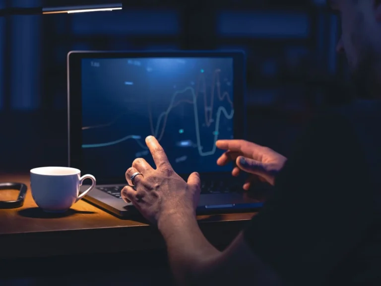 Homem analisa gráficos de investimentos no notebook à noite, buscando os melhores etfs brasileiros abril de 2026 para compor sua carteira.