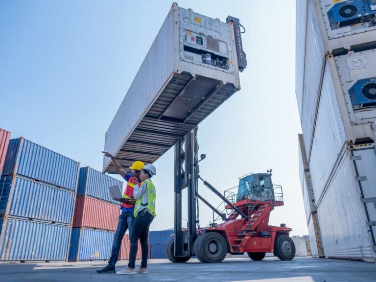 Trabalhadores calculando quanto custa importar um container da China