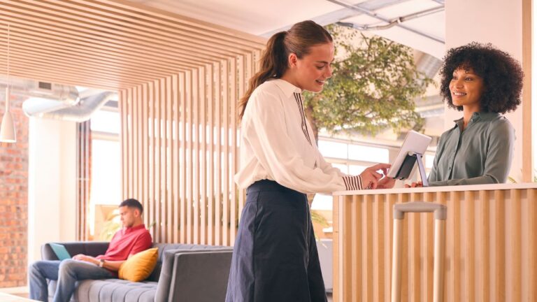 Recepcionista fazendo check-in digital em hospedagens