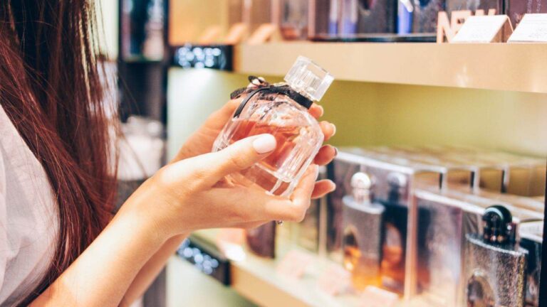 Mulher segurando frasco de perfume importado