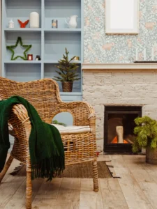 Sala aconchegante com sofá branco, almofadas, plantas e decoração em tons suaves.