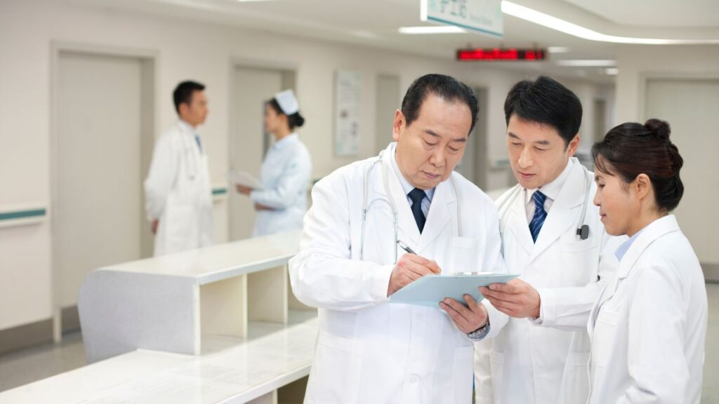 Médicos analisando prontuário no hospital.